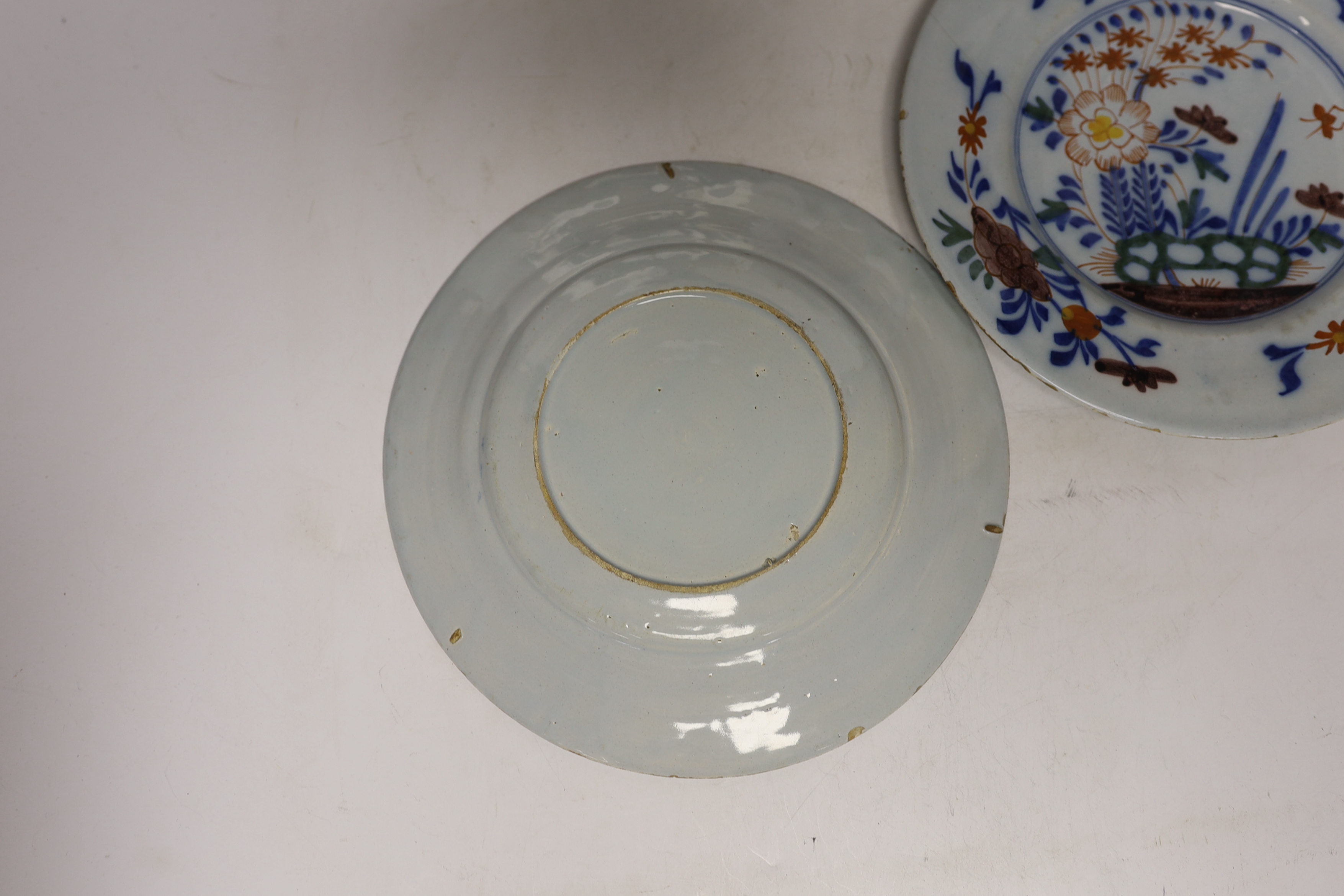A set of four mid 18th century Delft polychrome floral plates, 22.5cm diameter